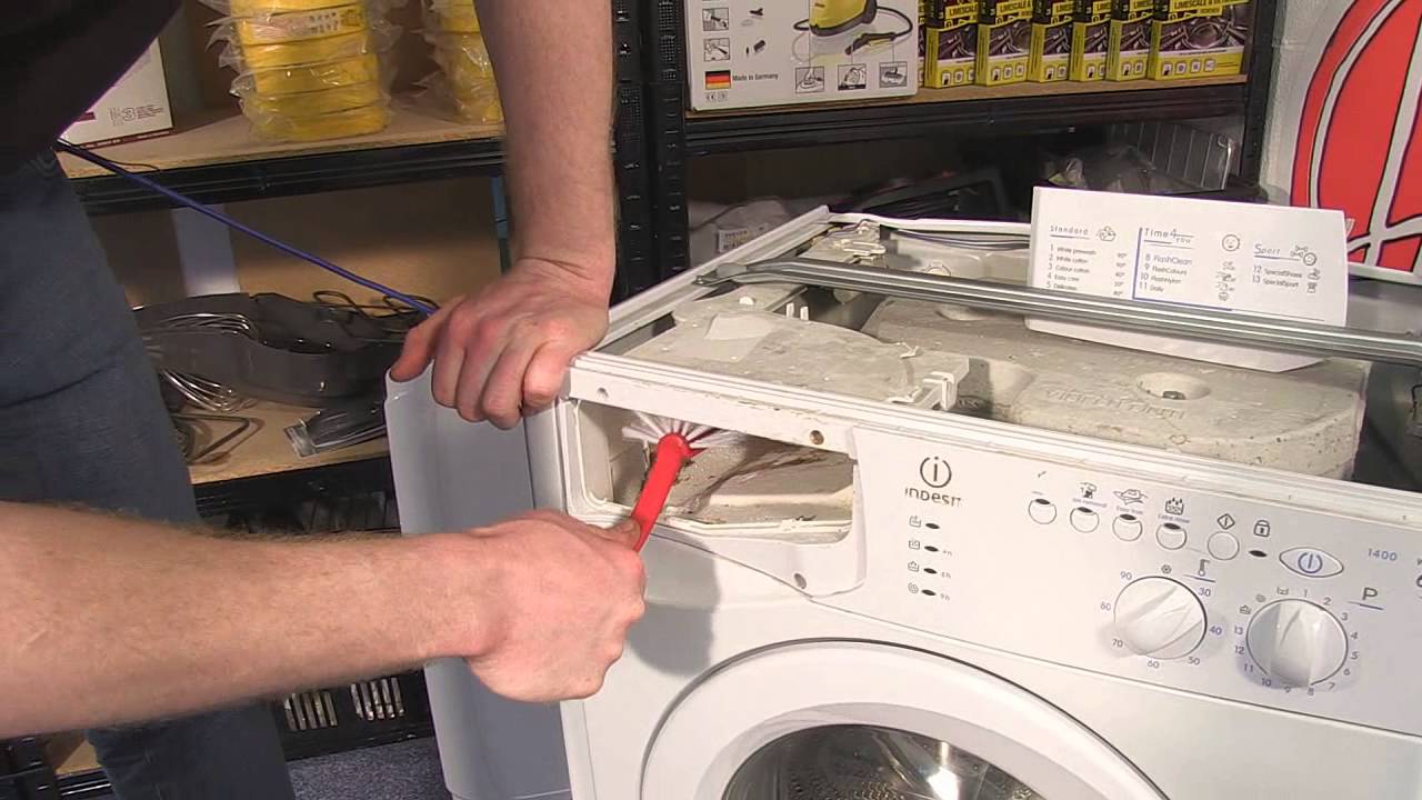 Мастер ремонтирует стиральную машину Indesit